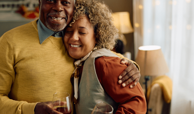 Family hugging with wine glasses.