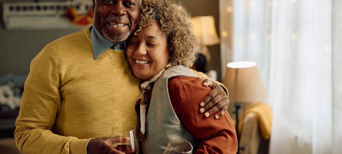 Family hugging with wine glasses.