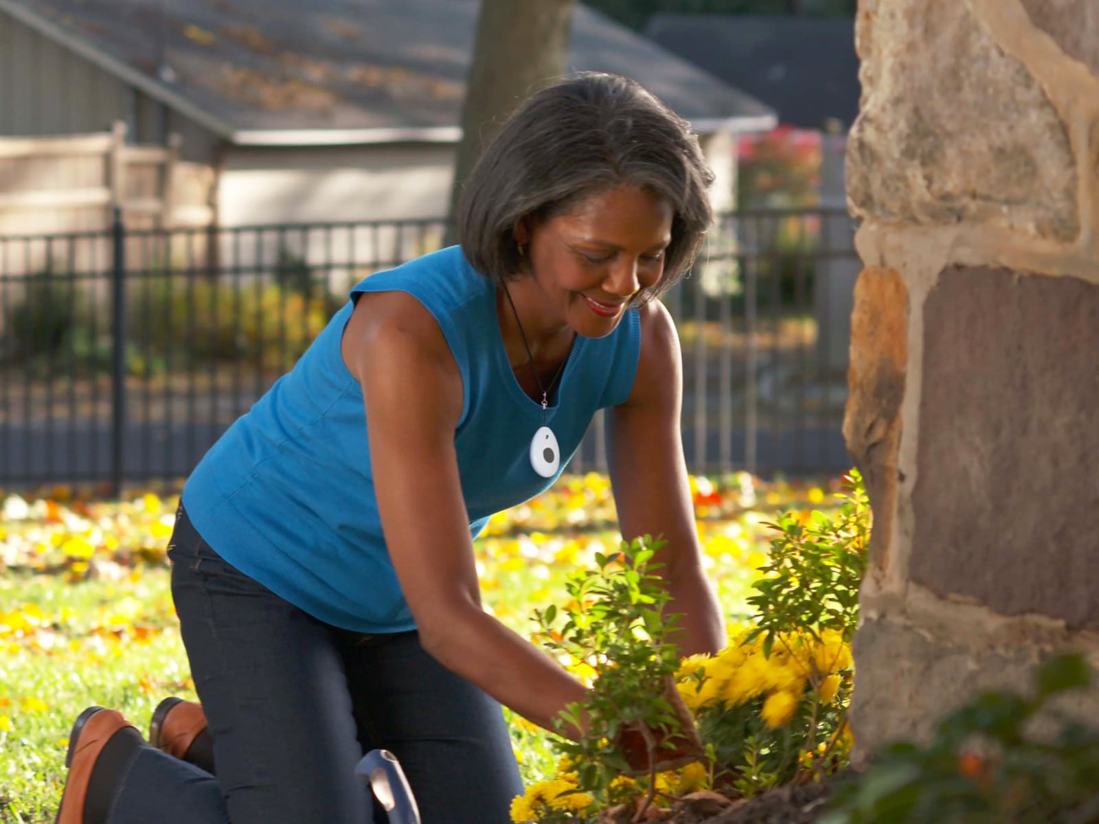 Woman gardening while wearing Medical Alert fall detection pendant