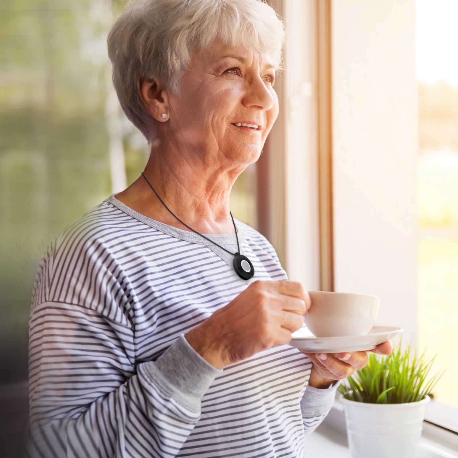 Woman drinking tea while wearing Medical Alert help button