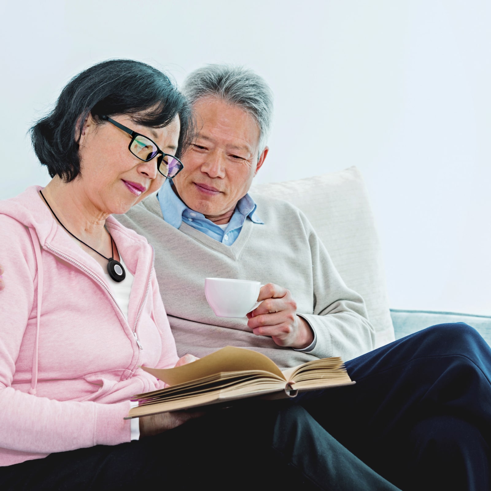 Woman wearing Medical Alert help button reads with husband