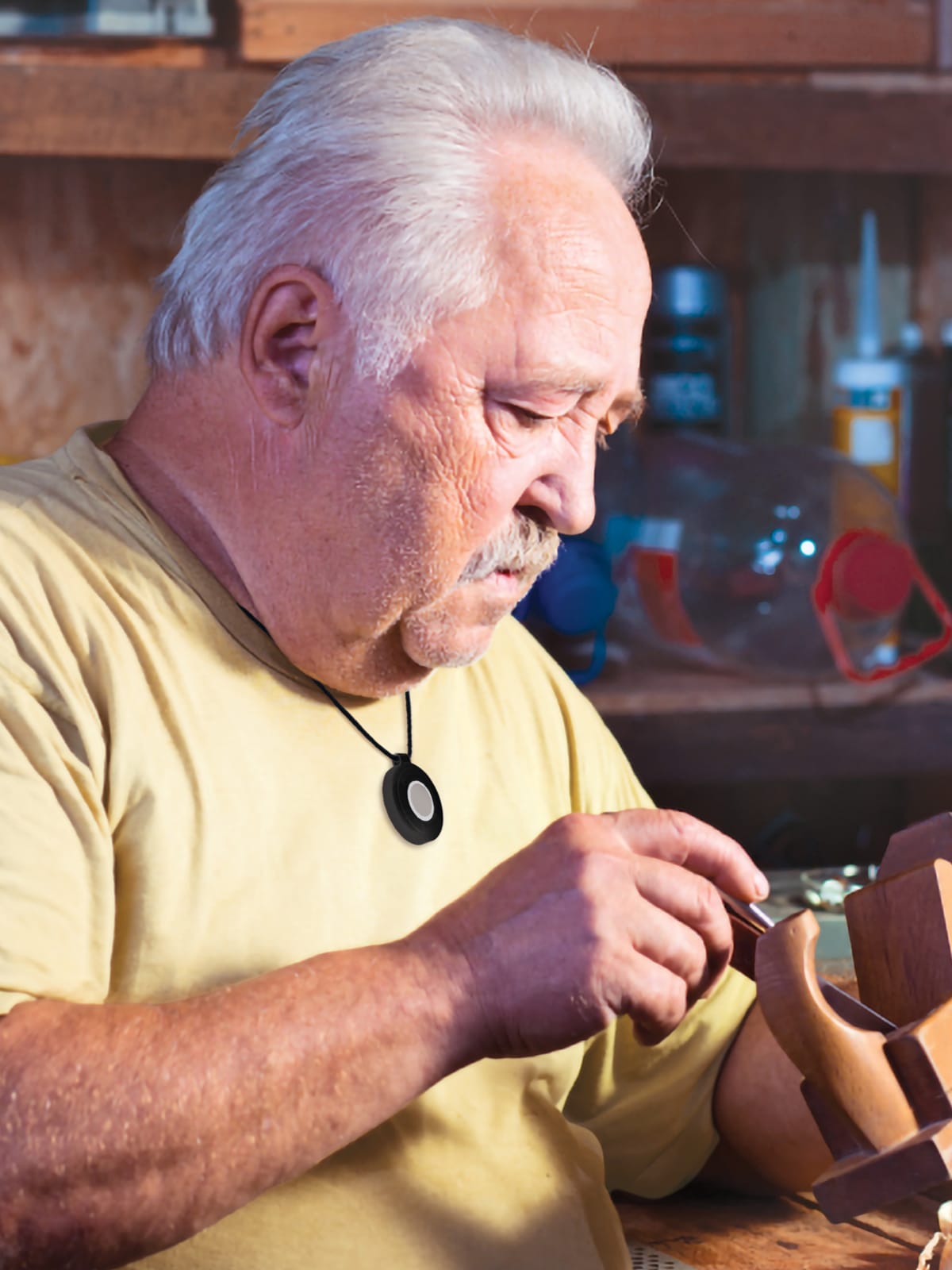 Man wearing Medical Alert help button does woodworking