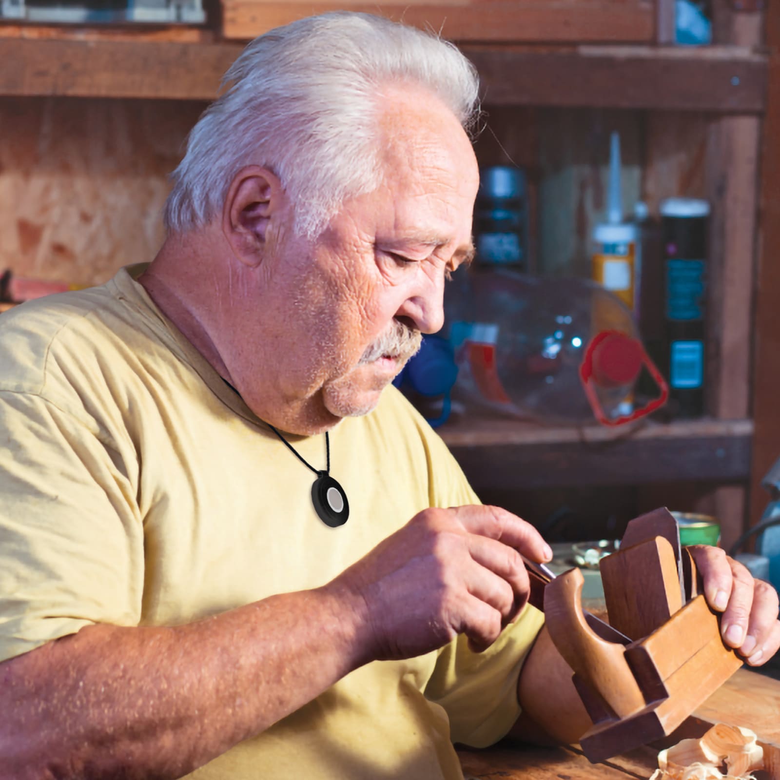 Man wearing Medical Alert help button does woodworking