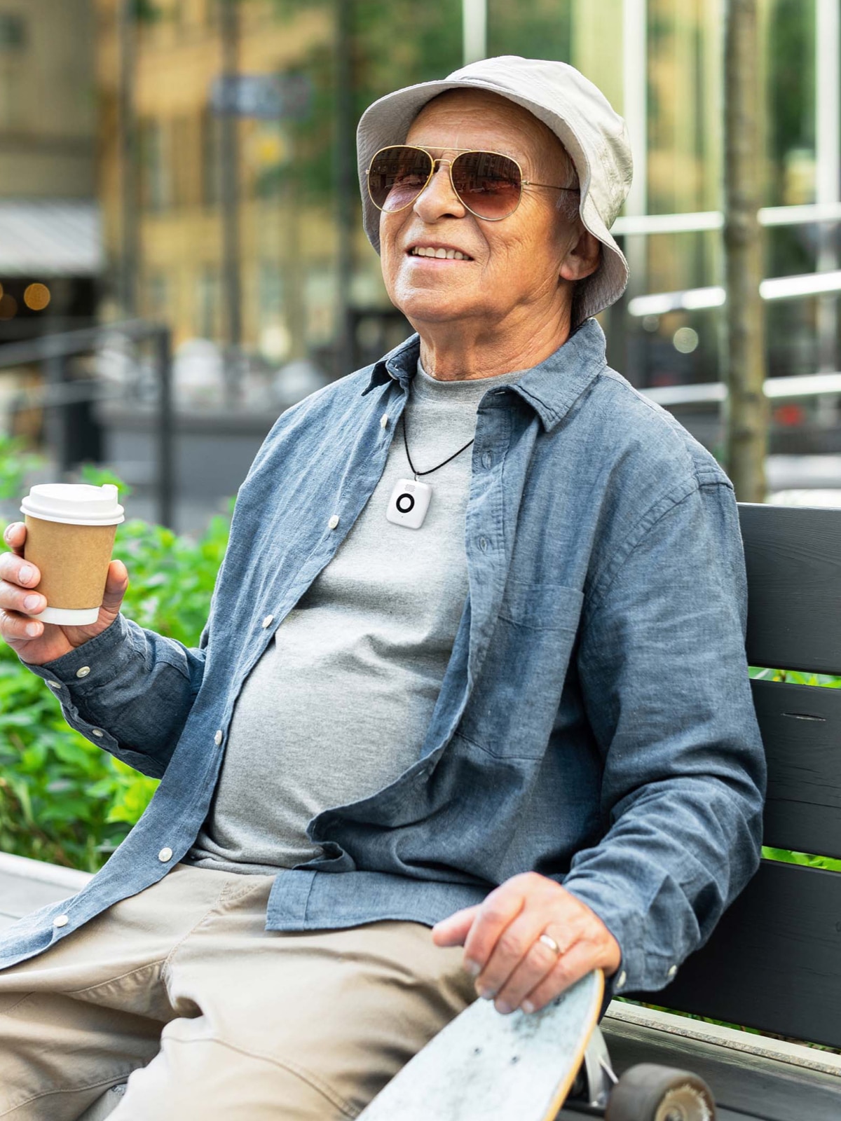 Man on park bench wearing Medical Alert Mini Mobile System