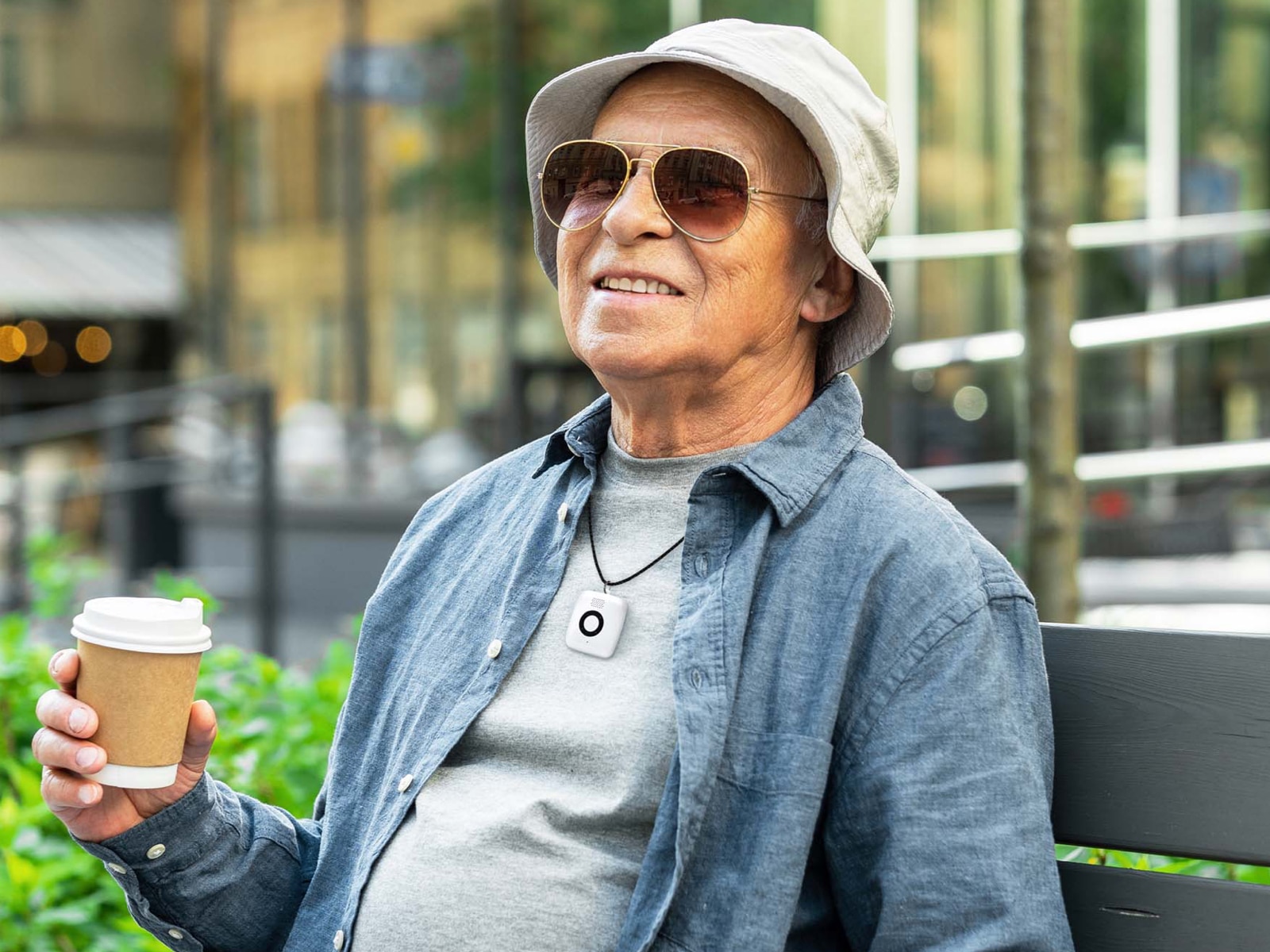 Man on park bench wearing Medical Alert Mini Mobile System