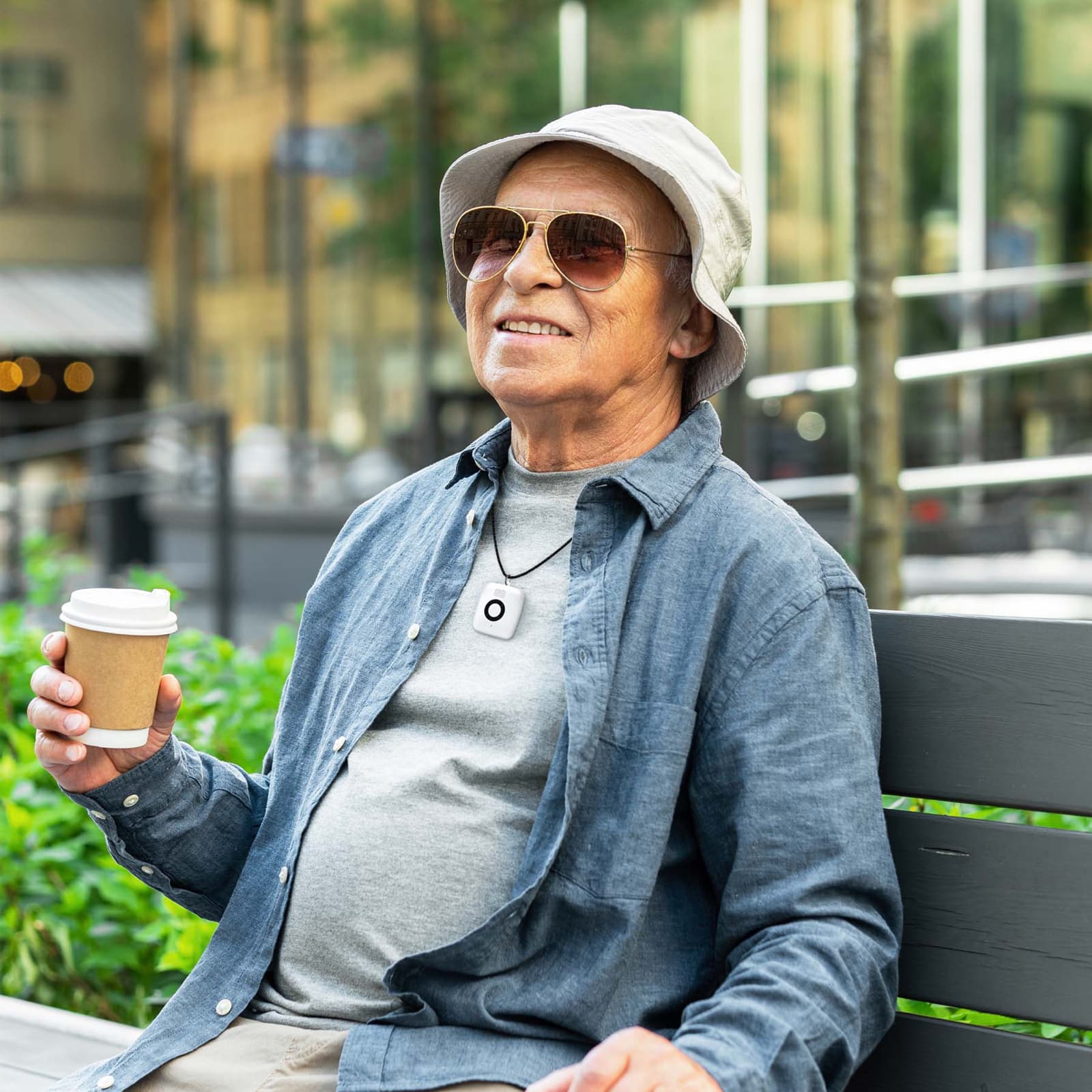 Man on park bench wearing Medical Alert Mini Mobile System