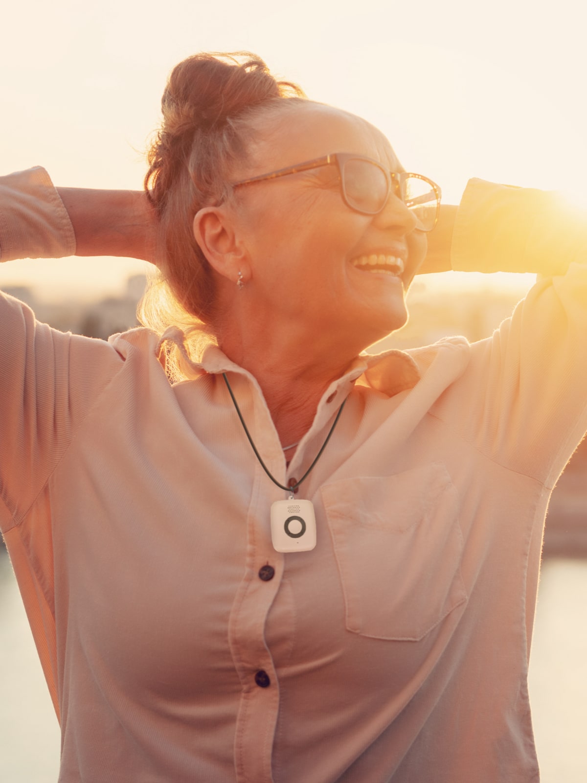 Woman at sunset wearing Medical Alert Mini Mobile System