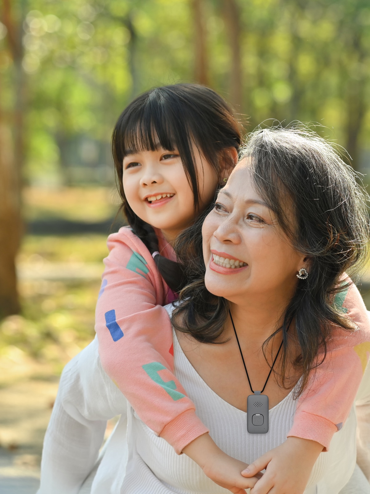 Grandmother wearing Medical Alert Mobile System carries granddaughter