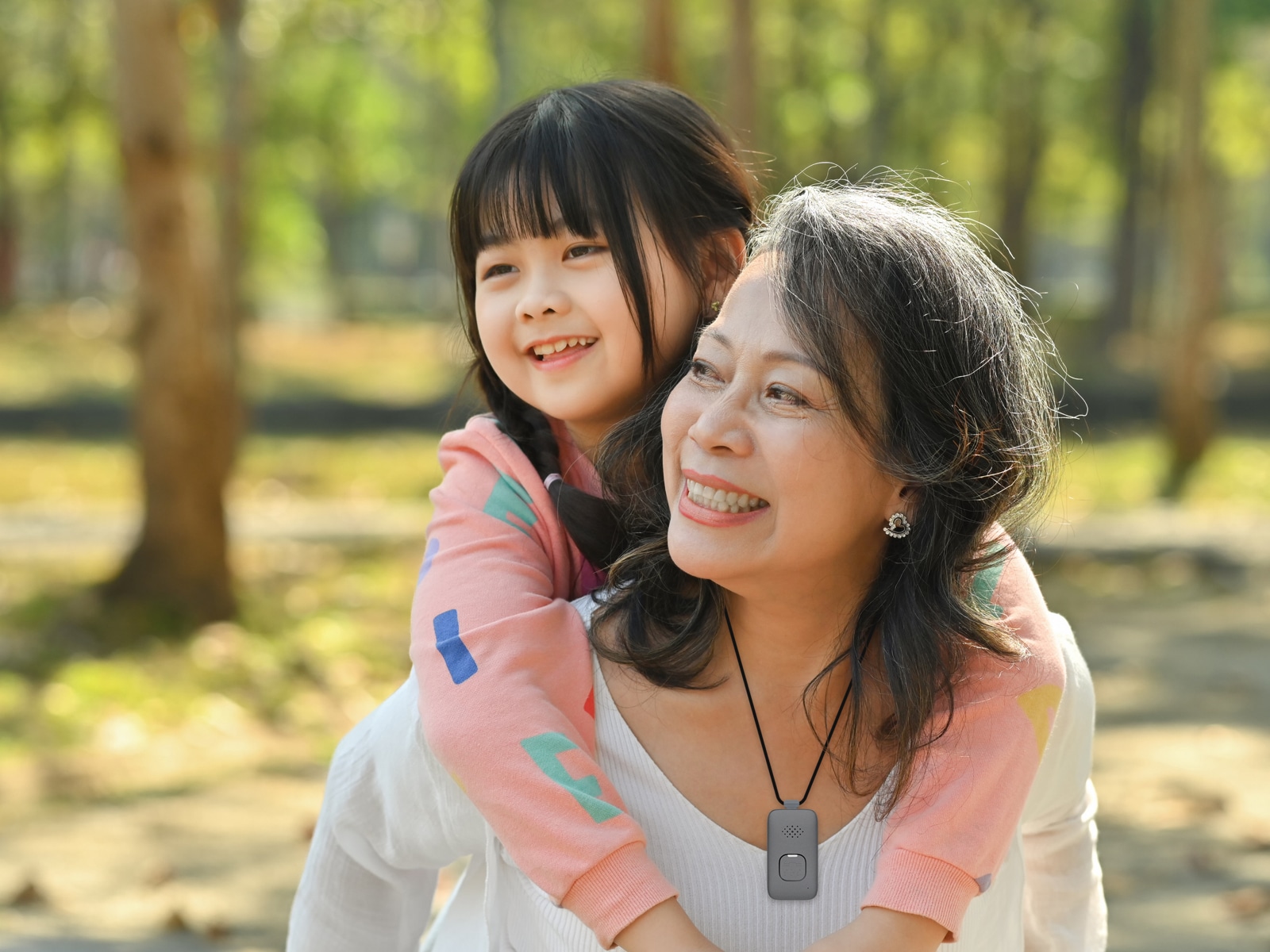 Grandmother wearing Medical Alert Mobile System carries granddaughter