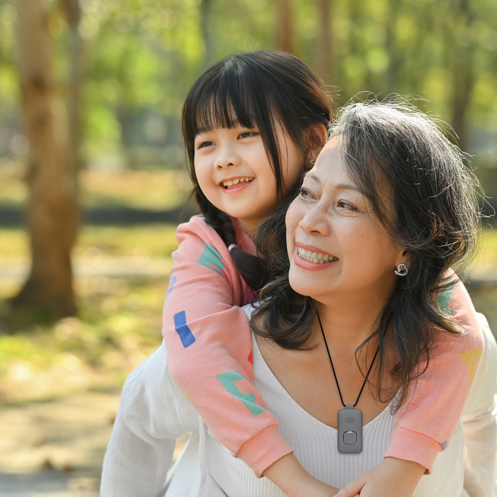 Grandmother wearing Medical Alert Mobile System carries granddaughter