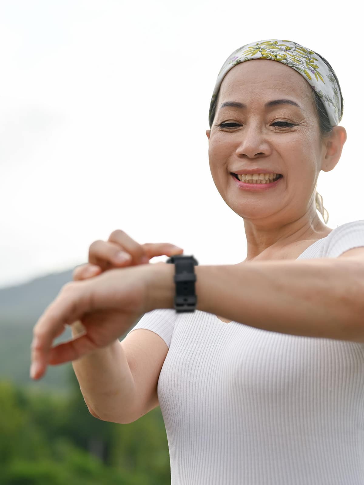 Hiking woman checks her steps on Medical Alert Smartwatch