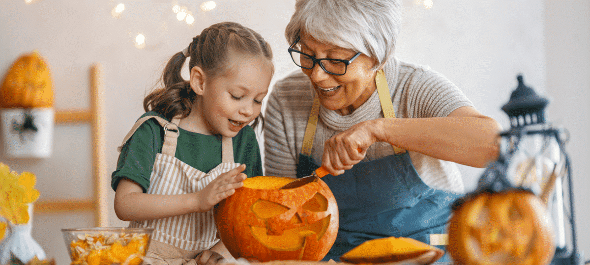 Grandmother And Granddaughter Carving Pumpkin