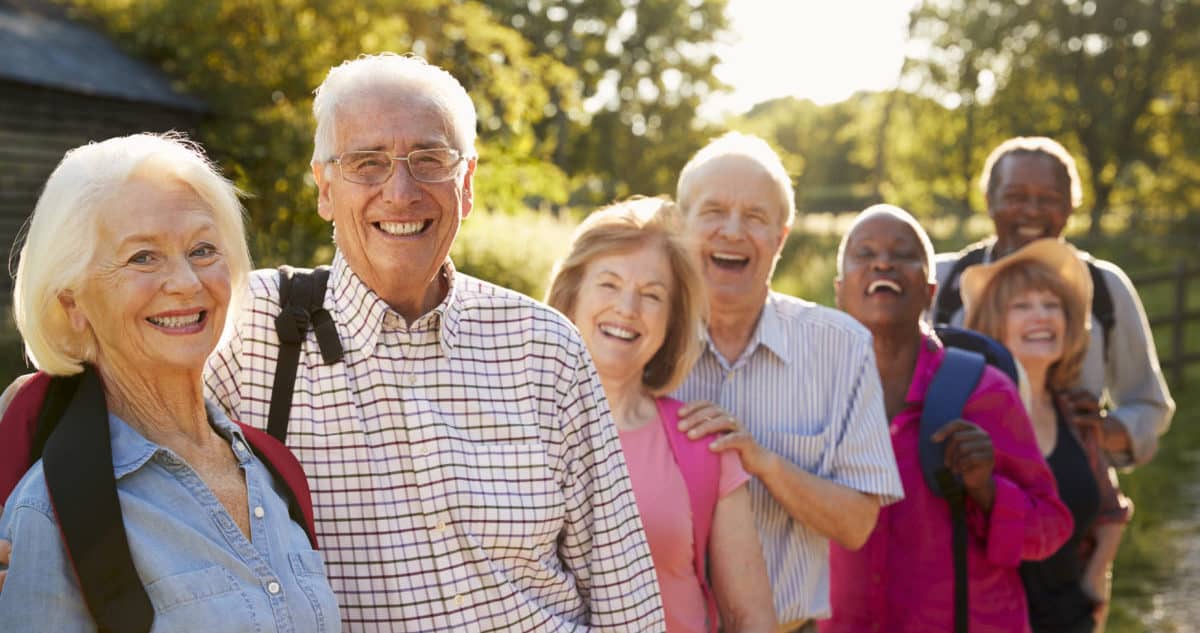 Portrait Of Senior Friends Hiking In Countryside